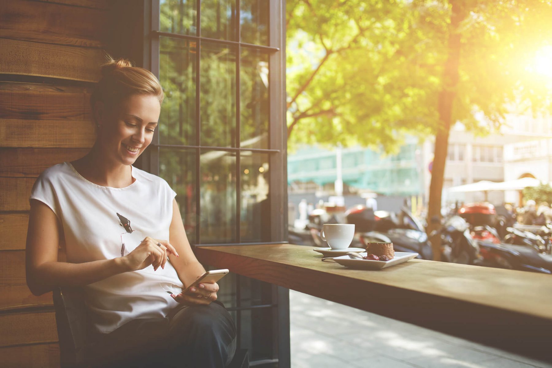 Woman sat at a table, looking at her phone